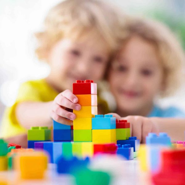 Wynyard Childcare - Kids play with colorful blocks. Little boy building tower at home or day care. Educational toy for young child. Construction creative game for baby or toddler kid. Mess in kindergarten playroom.